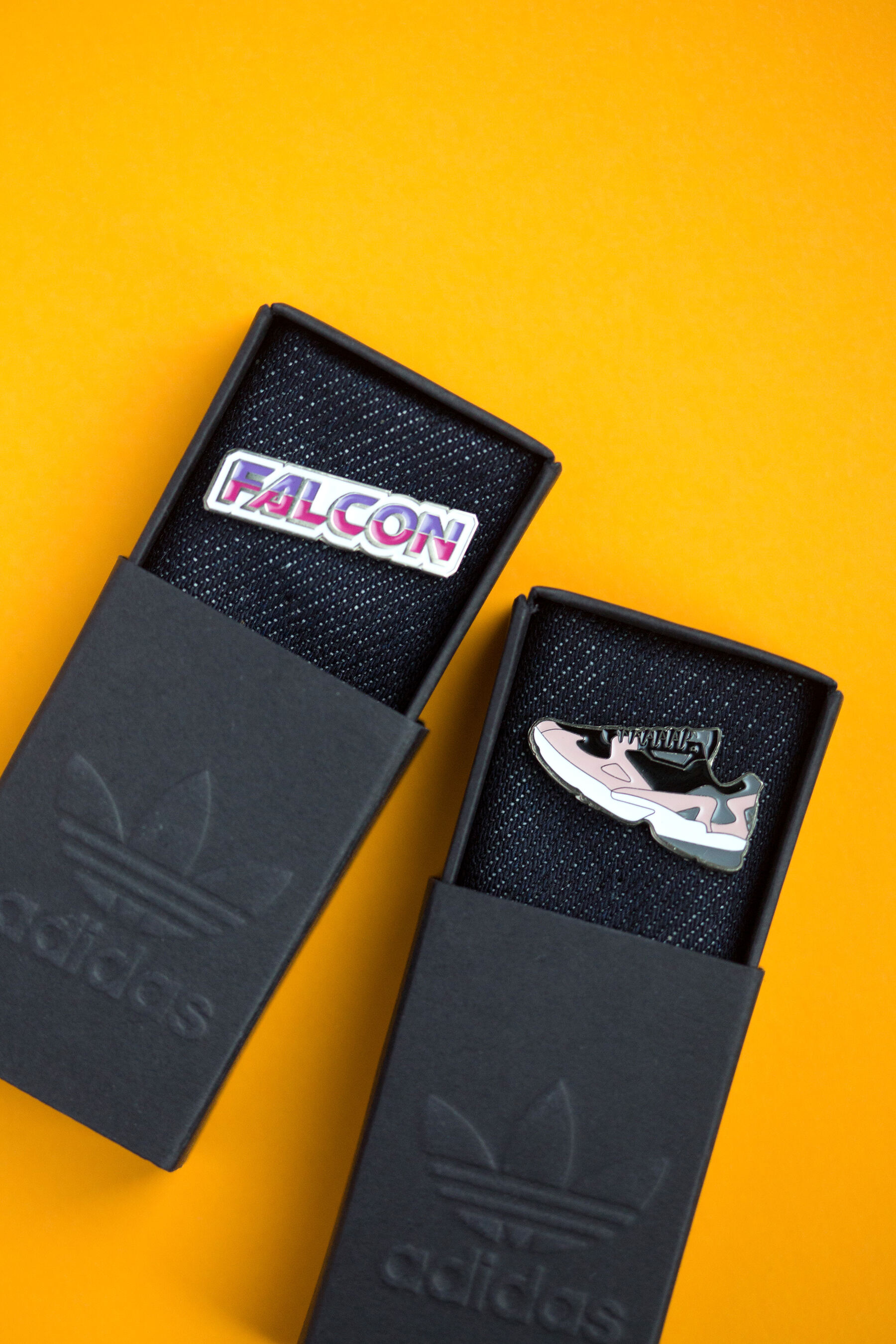 Pin metalowy w black matchbox z tłoczenieiem brand mark — full hero shot premium