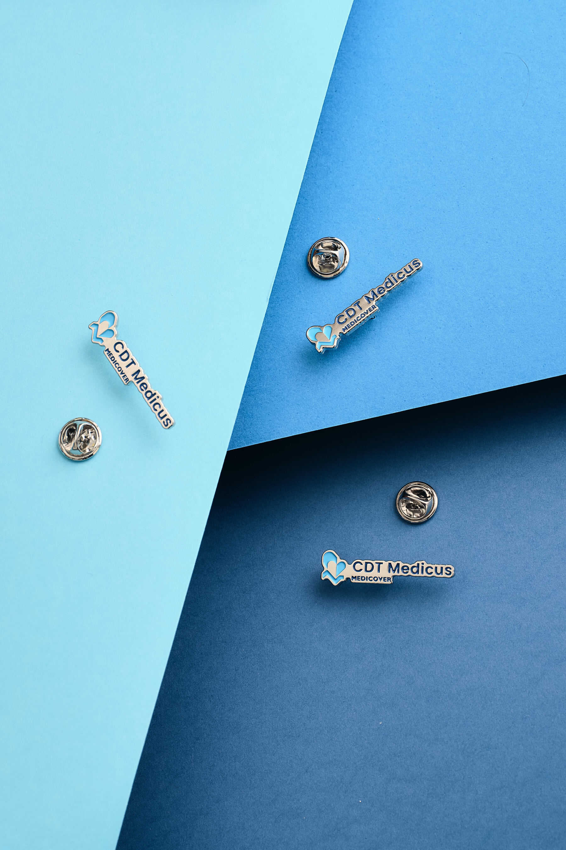 Casio pin — corporate identity, soft enamel na trzech odcieniach niebieskiego