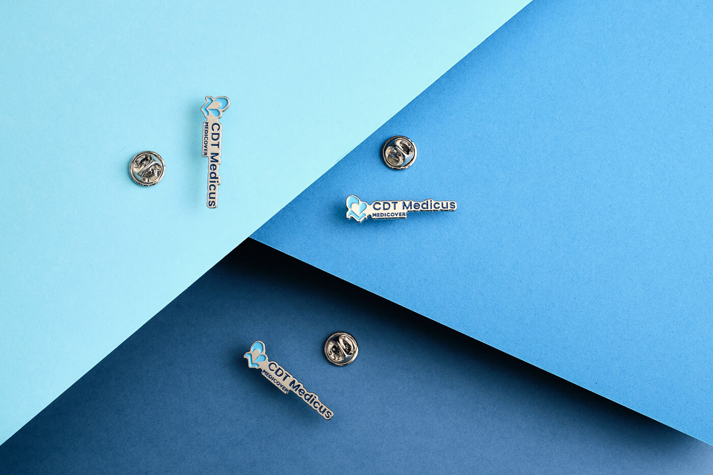 Casio — corporate pin na trzech odcieniach niebieskiego