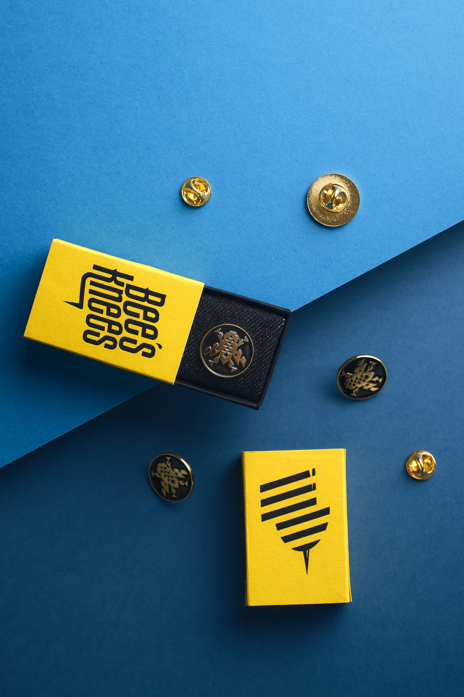 Detal opakowania — żółty matchbox z tłoczenieiem Bee's Knees na niebieskim tle